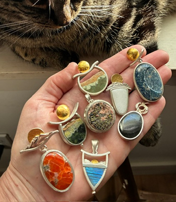 Hand holding 8 different pendants